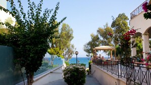 Un sentiero che conduce a una spiaggia con un gazebo e una ringhiera.