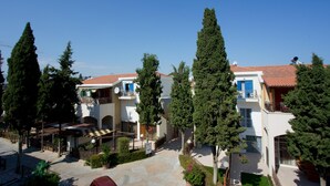 Un cortile con edifici, alberi e un pavimento piastrellato.