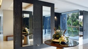 A modern interior with a round table, dark walls, and large mirrors. - Opera Exclusive Studio (Limassol)