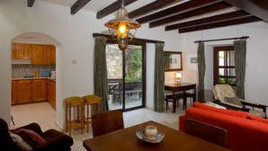 A cozy interior with a dining area, kitchen, and a red sofa. - Old Olive Mill House (Dhoros)