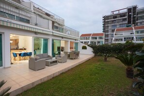 Un edificio moderno con un patio amoblado y un césped bien cuidado.