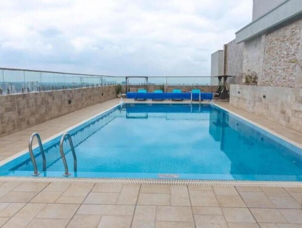Enjoy a refreshing swim in the rectangular pool surrounded by a tiled deck and offering a view of the surrounding landscape.