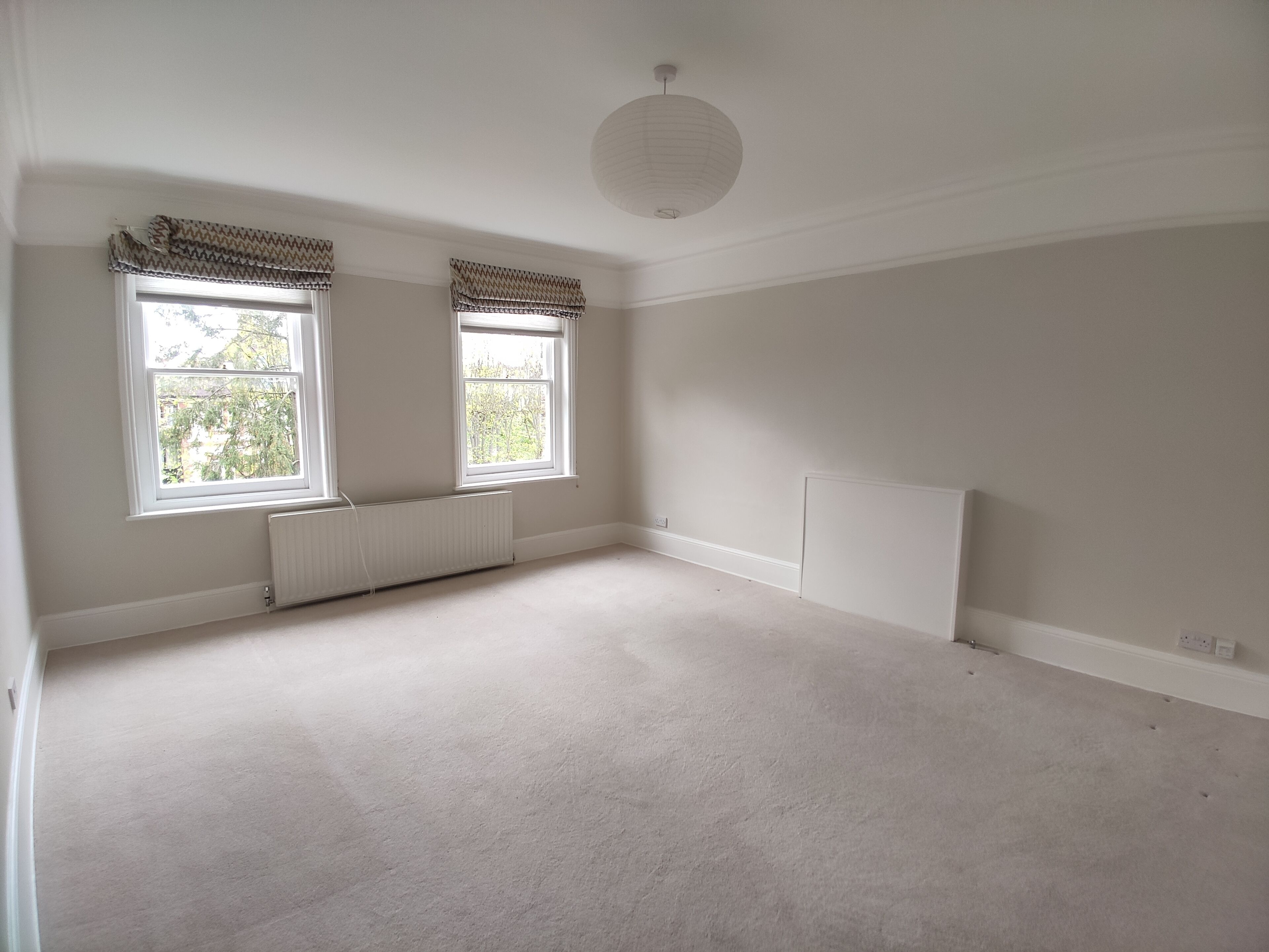 A room with two windows, white walls, and a white ceiling.