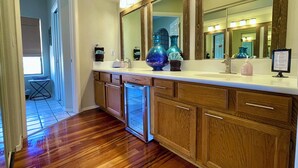 Une salle de bain moderne avec un grand miroir, des meubles en bois et un lave-vaisselle encastré.
