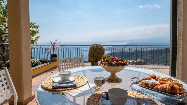 Une table dressée avec un saladier de fraises, des croissants et une tasse, offrant une vue panoramique.