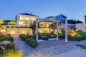 Stroll through the serene garden, surrounded by lush greenery and a charming pergola with swings.