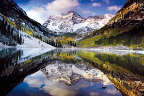 A mountain lake with reflections of the surrounding mountains and trees. - Terracehouse 52 (Snowmass Village)
