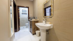 Une salle de bain moderne avec un lavabo blanc, un miroir et des toilettes.