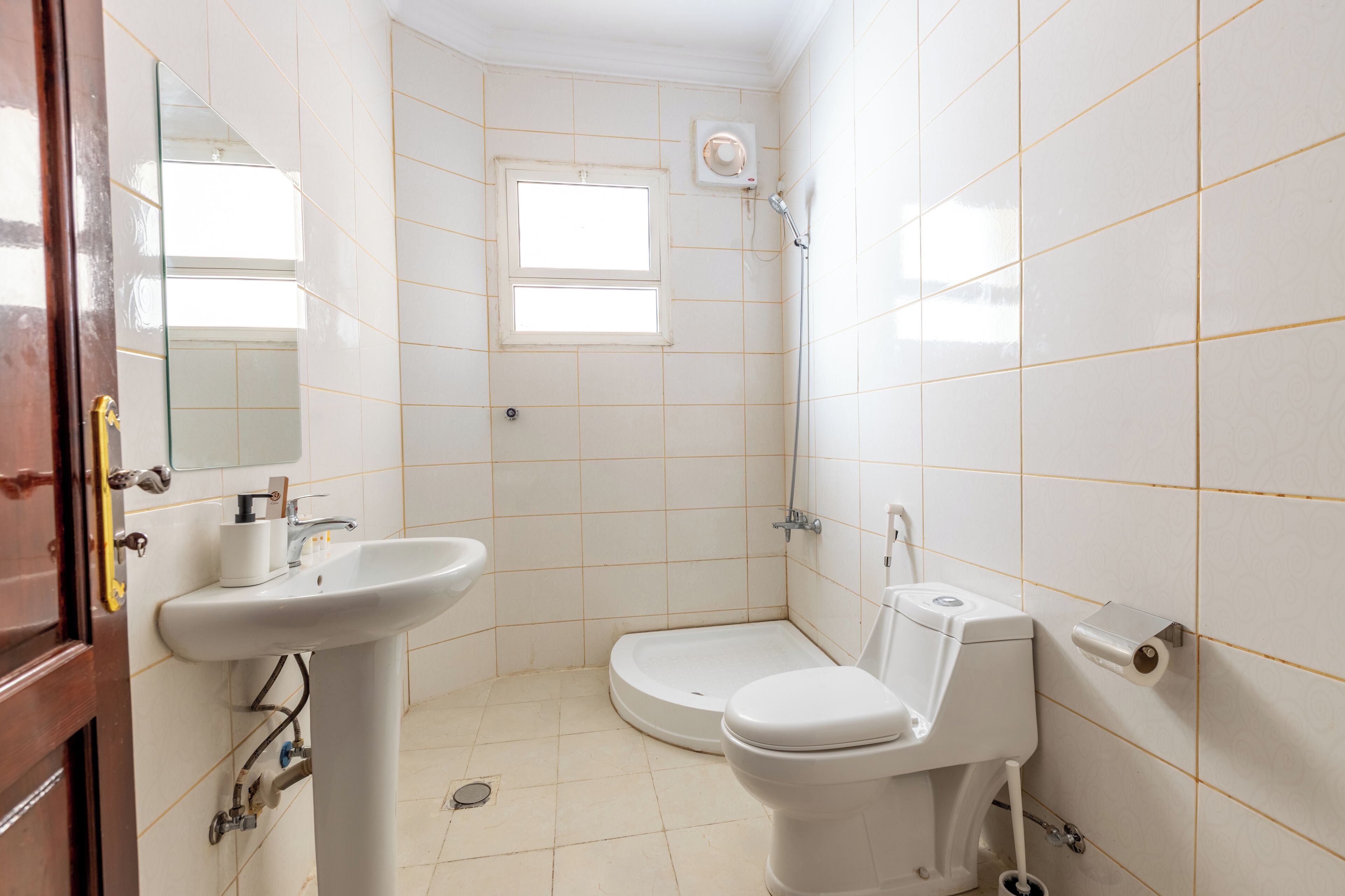 A small bathroom with a sink, toilet, and shower.