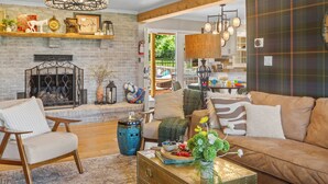 A living room with a fireplace, a sofa, a coffee table, and a chandelier. - Estate: Heated Pool, Hot Tub, Game Rooms, Pets (La Grange)