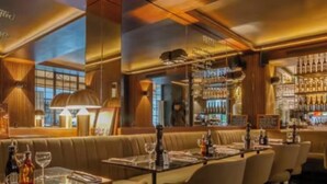 Een restaurantinterieur met een bar, zitplaatsen en uitzicht op de stad.