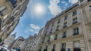 Une vue de rue avec des bâtiments historiques, un ciel dégagé et un panneau indiquant l’interdiction d’accès.