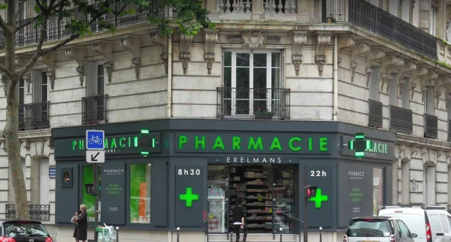 A pharmacy with a green sign, a bicycle symbol, and a green cross symbol indicating services.