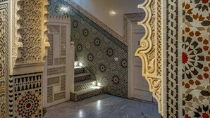 An ornate hallway with intricate tile work and a staircase leading to a higher level. - Riad Glatt K: a Luxurious Oasis in the Heart of Marrakech. (Marrakech)