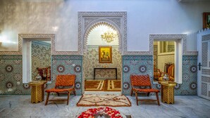 A room with a fountain, patterned walls, and two wooden chairs. - Riad Glatt K: a Luxurious Oasis in the Heart of Marrakech. (Marrakech)