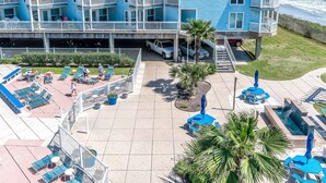 Um hotel com vários andares, varandas, área de piscina e vista para o mar.