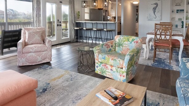 A spacious living room with a large window, a kitchen area, and a dining space. - Walk to the Beach Ocean Views Yard Game Room (Galveston)