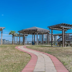 Un parque con quioscos de madera, un sendero curvo y una valla.