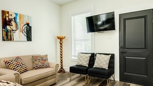 A living room with a beige sofa, a black sofa, and a black door. - Have fun Relax and Stay Close to the Beach (Galveston)