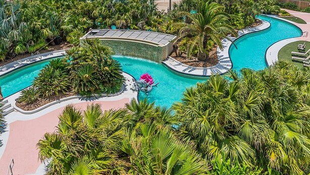 A resort with a large pool, palm trees, and a view of the ocean. - Warm and Welcoming Views at Diamond Beach (Galveston)