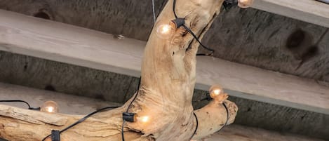A rustic wooden structure with exposed beams and a light fixture with multiple bulbs.