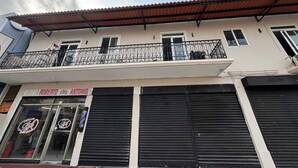A building with a closed shop named "Roberto Antonio" and a balcony with a metal railing. - RESIDENCIAL LA MALVARROSA (Panama City)