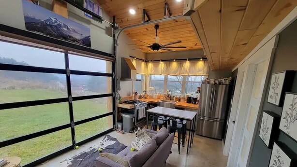Eine geräumige Küche mit Essbereich, großen Fenstern und einem Deckenventilator.