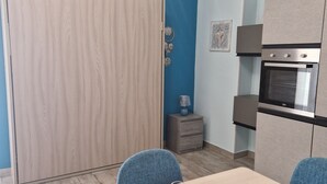 Une cuisine compacte dotée d’un four encastré et d’une armoire en bois.