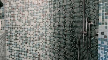 Une douche équipée d’un pommeau de douche à main et d’un pommeau de douche à main avec un flexible.
