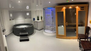 A spa room with a hot tub, a glass-enclosed shower, and a wooden cabinet. - The Chatwal Boutique Hotel (Blackpool)