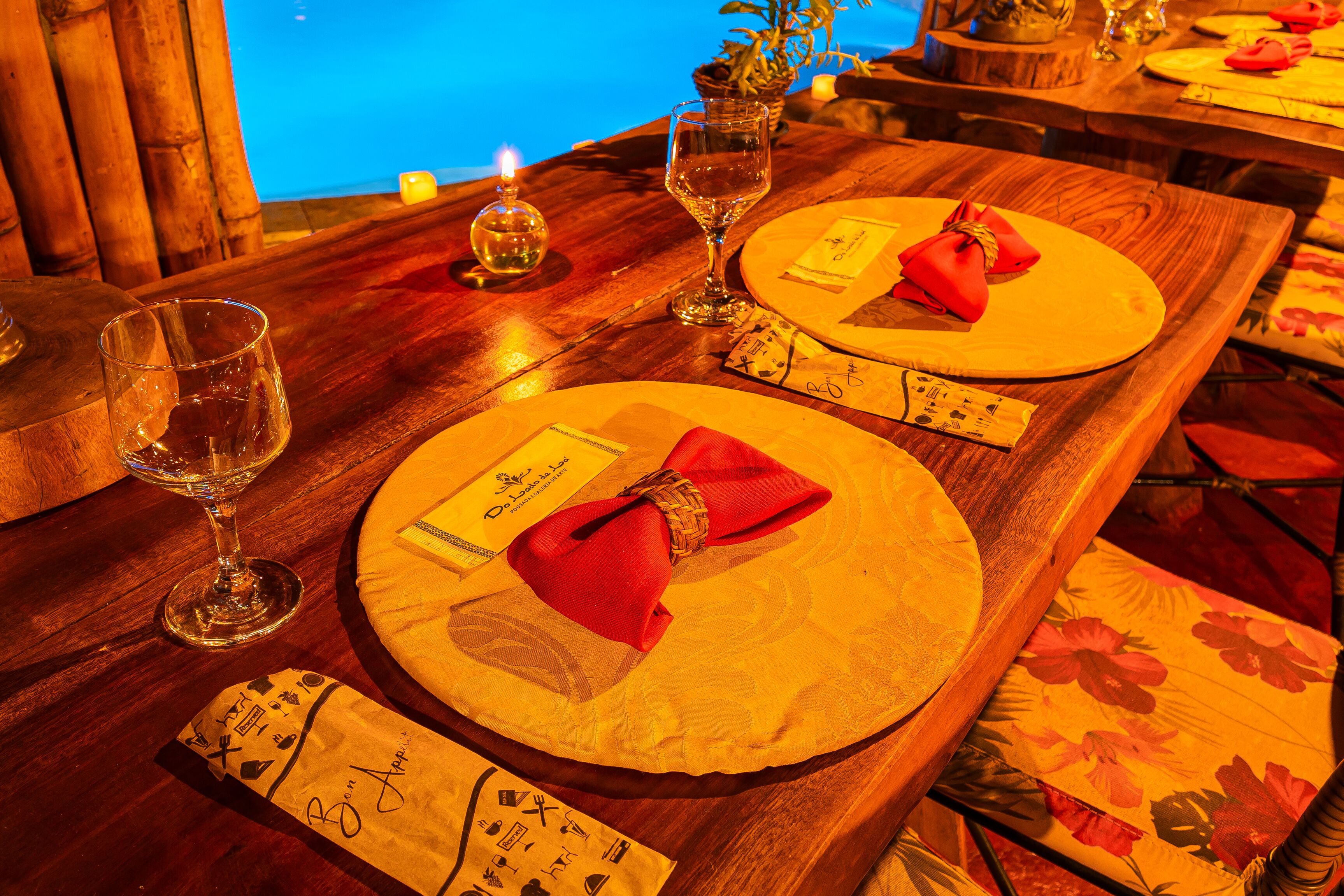 A wooden dining table with round place settings, each with a folded napkin and a menu card.