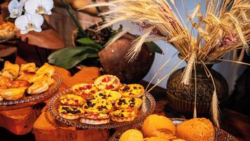 Variedad de alimentos sobre una mesa, incluyendo pasteles y pan.