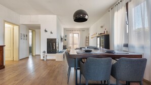 Une cuisine moderne avec une table à manger, des chaises et un grand luminaire suspendu.