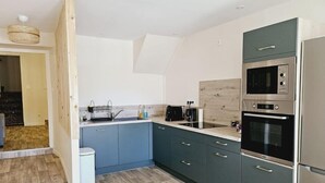 A modern kitchen with grey cabinets, stainless steel appliances, and a wooden floor. - Apartment - shaded terrace (Marsanne)