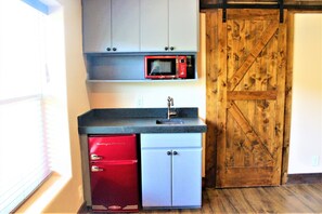 A compact kitchen with a red refrigerator, a microwave, and a sink. - The Rustic Inn- Family Friendly Near Fiesta Texas (San Antonio)
