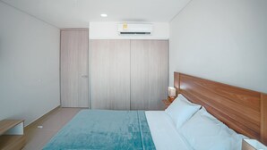 A bedroom with a bed, a nightstand, a wooden headboard, a wardrobe, and an air conditioning unit. - Armonioso loft de 1 Hab en Cartagena  (Cartagena)