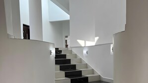 A modern staircase with alternating black and white steps, leading to a bright interior space. - The Baroness (Bulawayo)