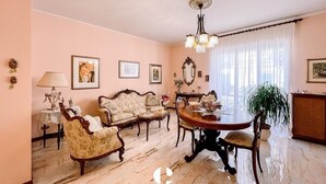 Un vaste salon doté d’un sol en marbre, d’une table à manger ronde et de meubles classiques.