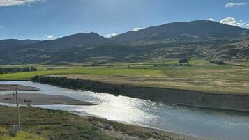 A river flowing through a valley with mountains in the background.