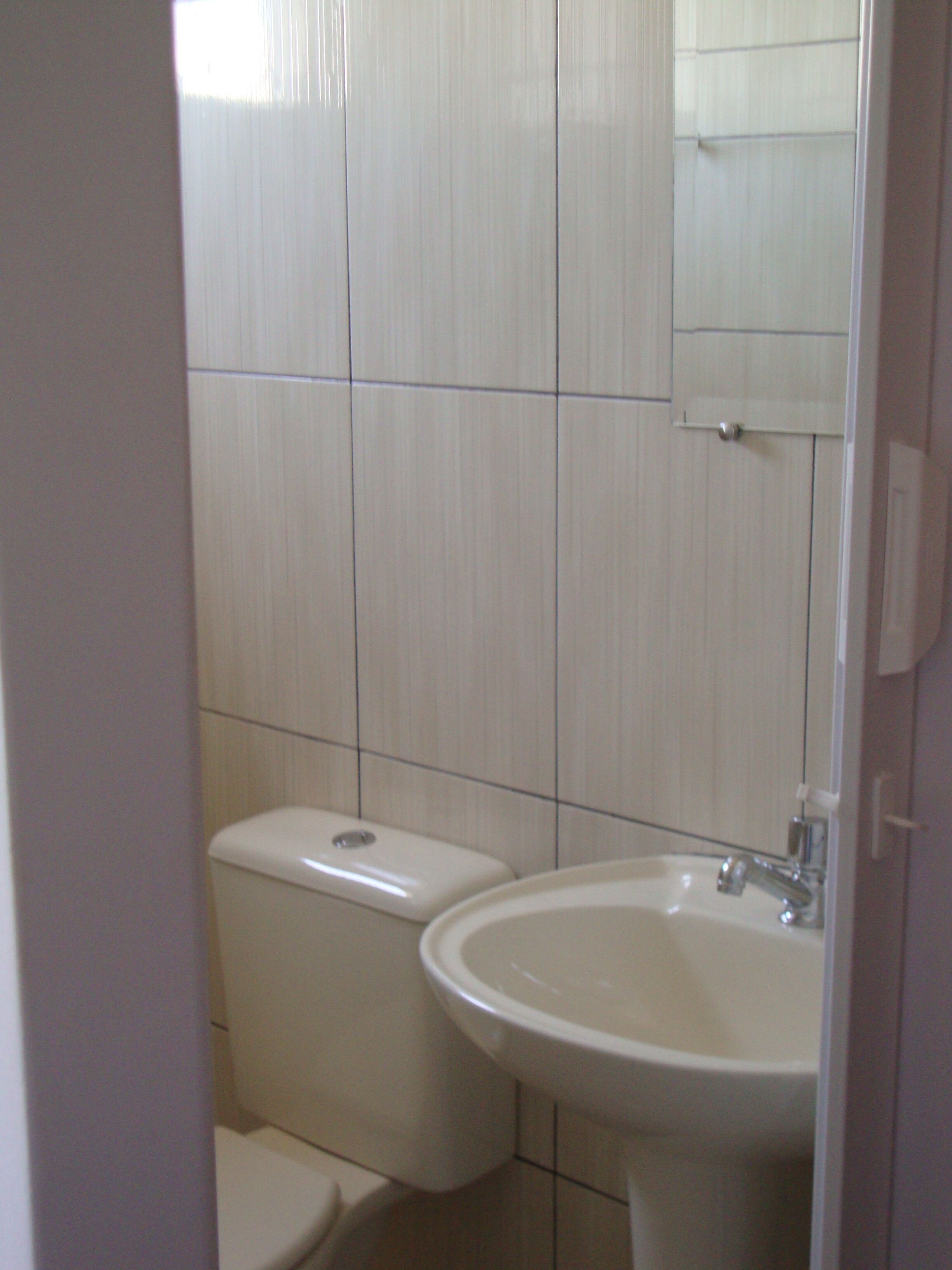 Een badkamer met toilet en wastafel.