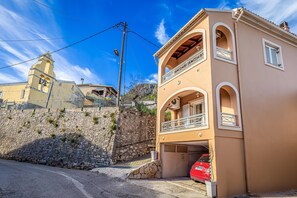 Ein zweistöckiges Gebäude mit Balkon und Garage.