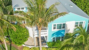 A two-story house with a blue exterior, a covered porch, and a small pool. - Clean Spacious Waterfront 2bd 2ba Sleeps 8 (Fort Pierce)