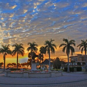 A landscaped area with palm trees and a building in the background. - 8BD Ft Pierce Beach Getaway - Great for Family Group (Fort Pierce)