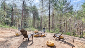 An outdoor seating area with chairs and tables, surrounded by a forest. - Near Hiking & Fishing: Reliance Home w/ Fire Pit! (Reliance)