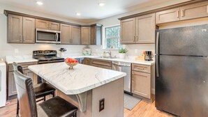A modern kitchen with a central island, stainless steel appliances, and light wood cabinetry. - Near Hiking & Fishing: Reliance Home w/ Fire Pit! (Reliance)