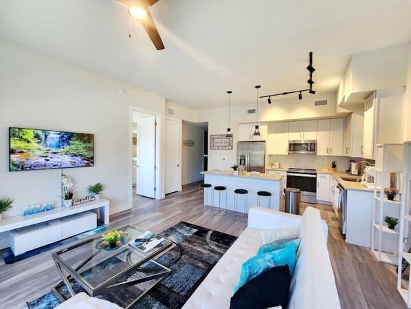 A modern apartment with a living room, kitchen, and dining area.