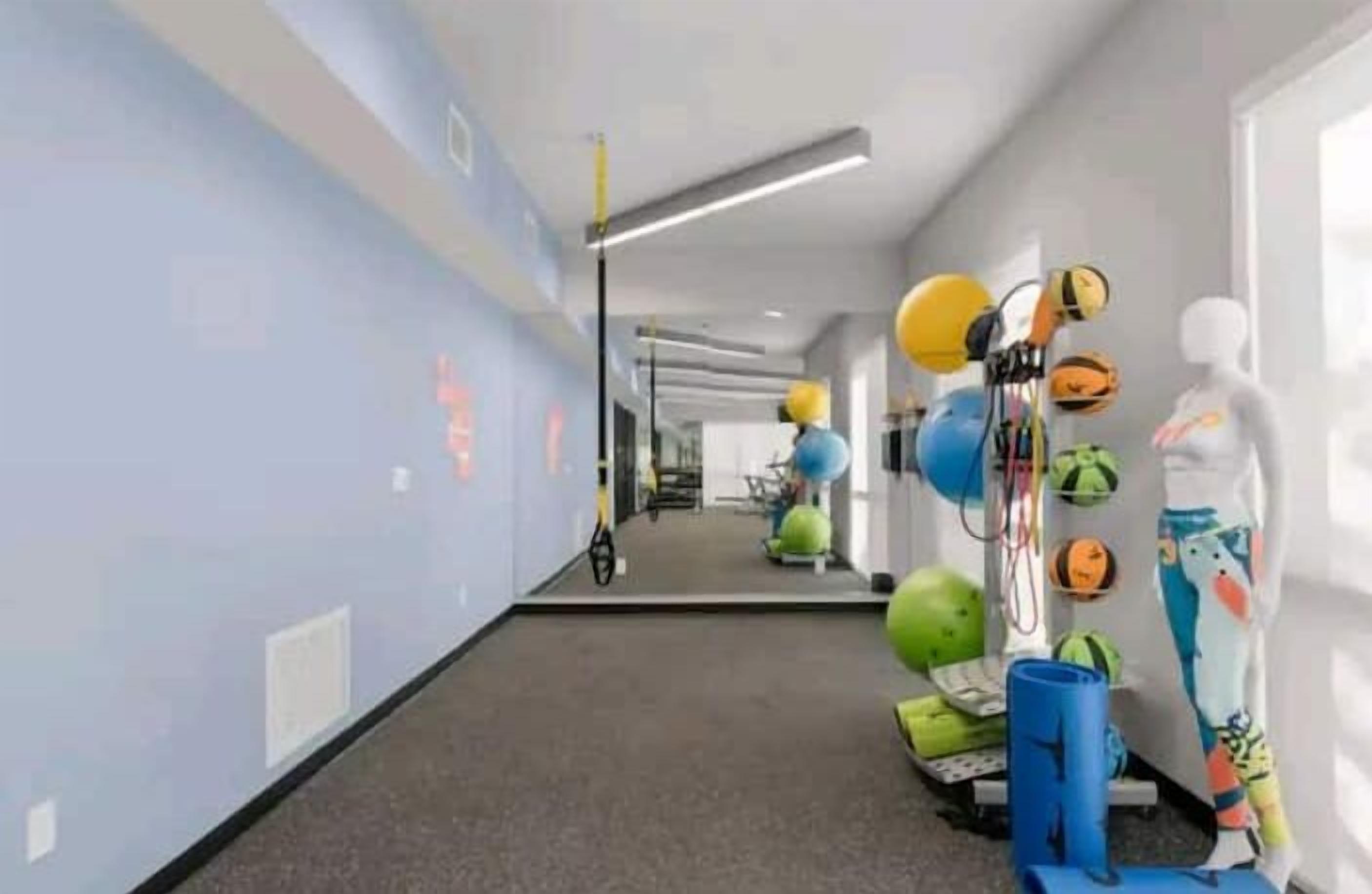 Un couloir équipé de matériel de musculation et sur lequel est placé un mannequin.