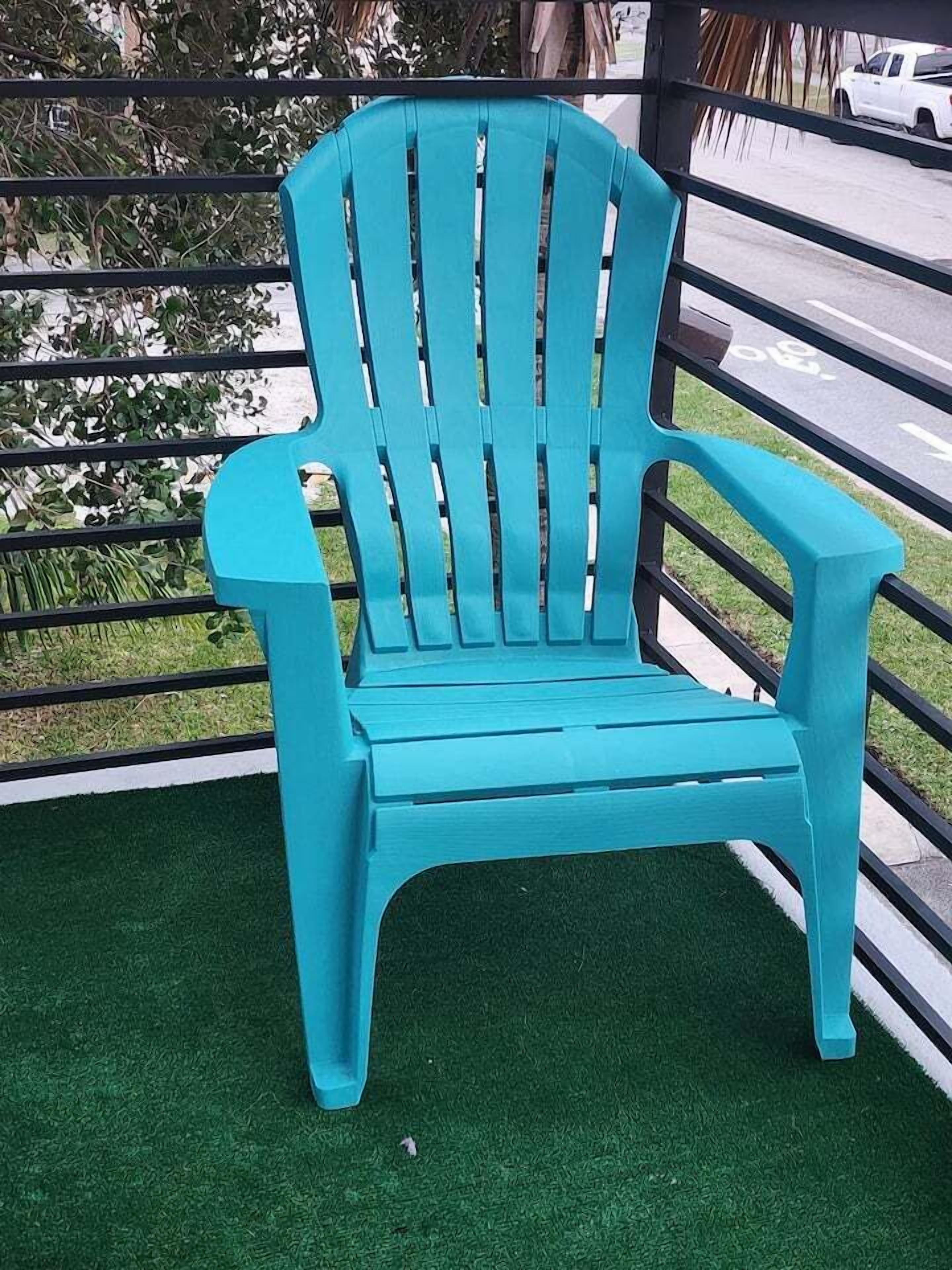 Ein türkisfarbener Adirondack-Stuhl mit hoher Rückenlehne und Armlehnen, platziert auf künstlichem grünen Rasen.