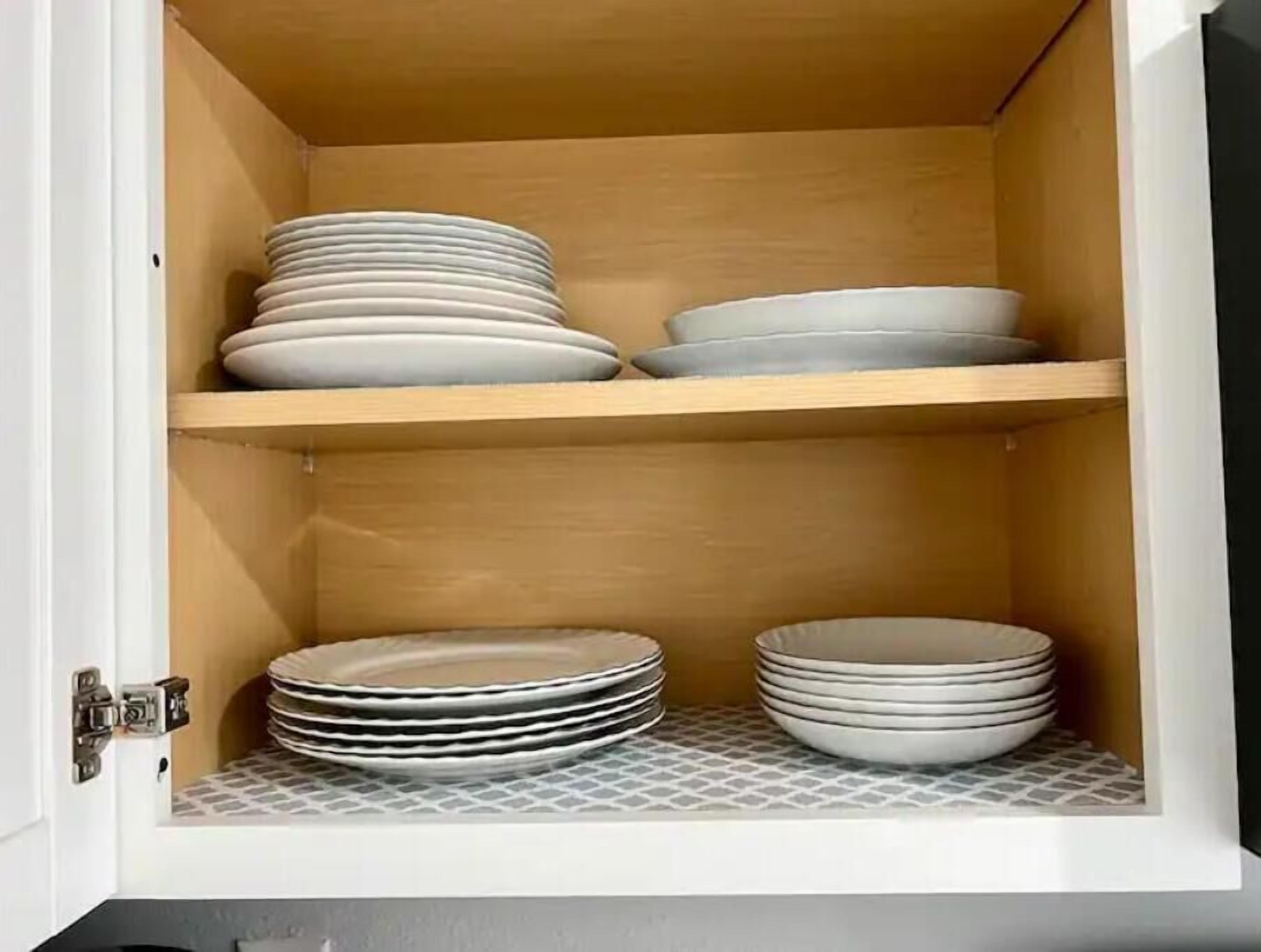 Un mueble con dos estantes, cada uno con pilas de platos.