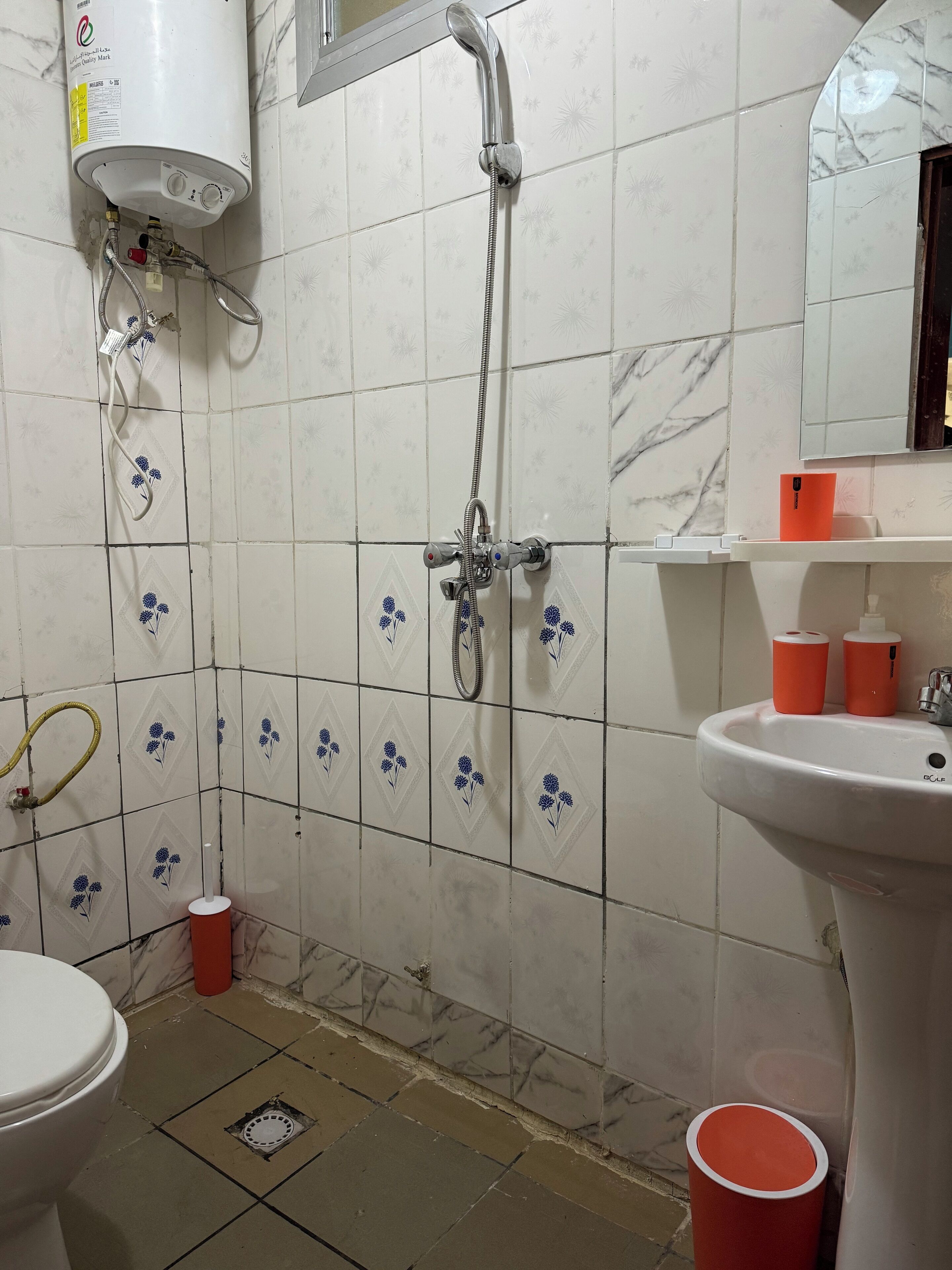 A bathroom with a shower, toilet, and sink.